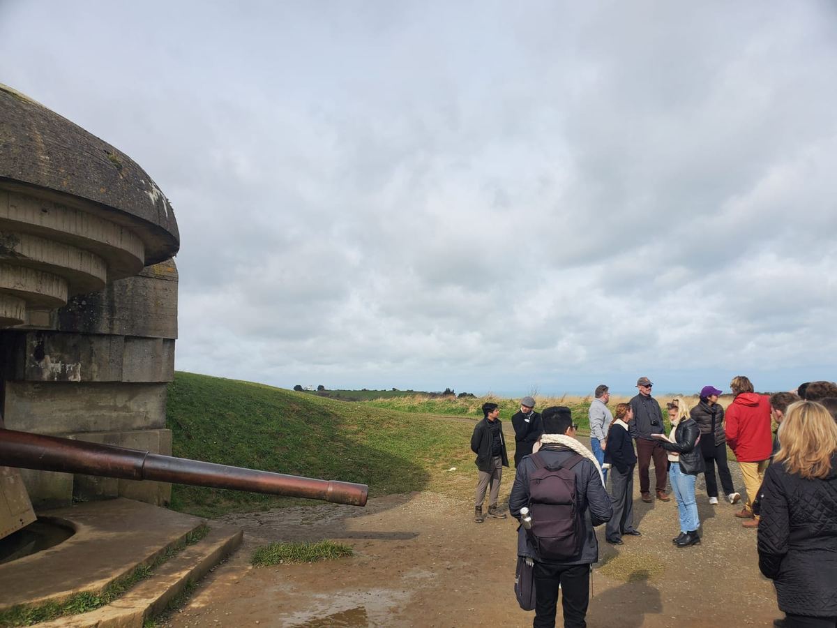 Students walking between concrete coastal bunkers during a staff ride